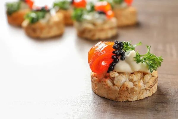 Delicioso canapé con caviar negro en la mesa — Foto de Stock