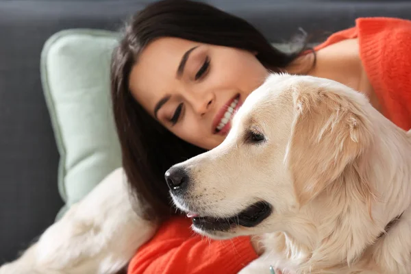 Ung kvinna med hund inomhus. Vänskapen mellan husdjur och ägare — Stockfoto