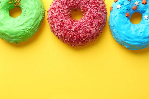 Deliciosos donuts coloridos no fundo da cor — Fotografia de Stock