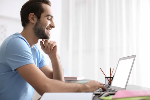 Studente con computer portatile che studia a tavola al chiuso — Foto Stock