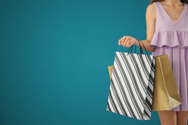 Arkaplanda alışveriş torbaları olan güzel genç bir kadın.