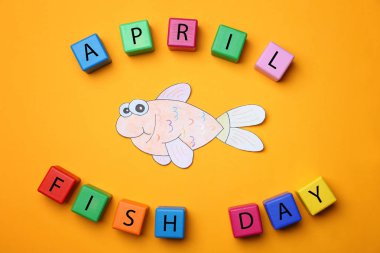 Kağıt balık ve küpler renk arka plan üzerinde. Nisan aptal gün kutlama