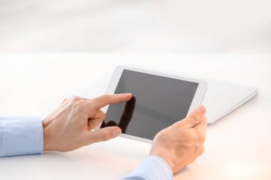 Genç adam masada tablet bilgisayar kullanarak
