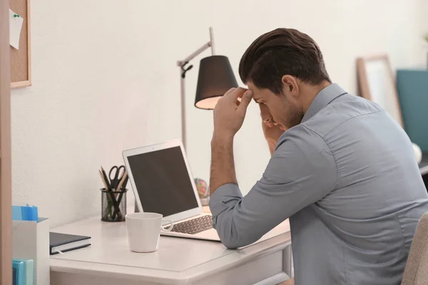 Jeune homme travaillant à table au bureau — Photo