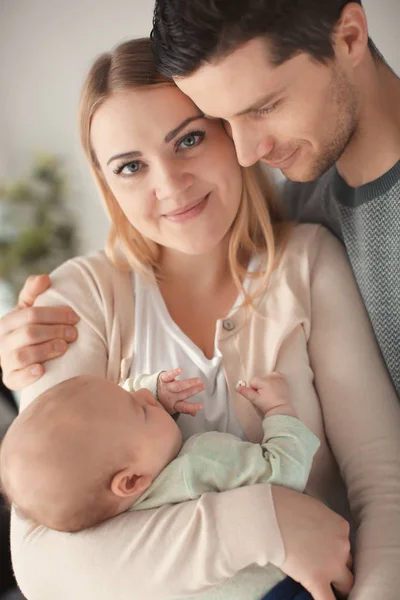 Junge Eltern mit schlafendem Baby zu Hause — Stockfoto