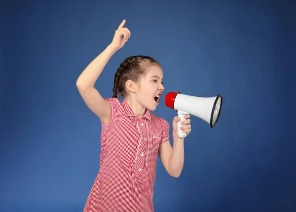 Menina pequena emocional gritando em megafone no fundo de cor — Fotografia de Stock