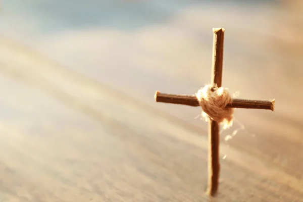 Cruz hecha a mano sobre fondo de madera borrosa — Foto de Stock