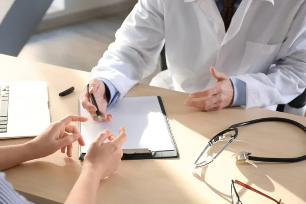 Doctor consulting patient in clinic — Stock Photo, Image