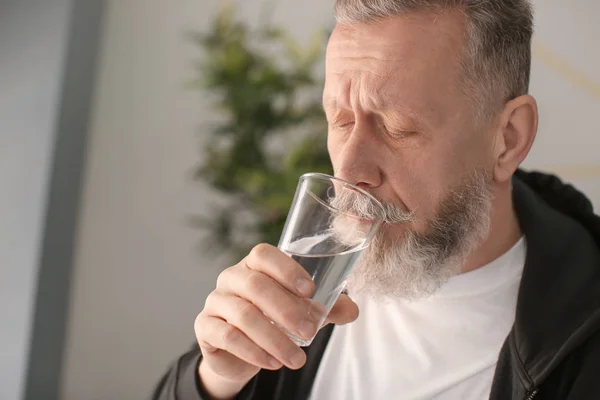 Portrét starší muž se sklenicí vody uvnitř — Stock fotografie