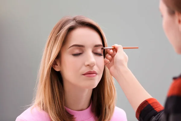 Make-up-Artist arbeitet mit schönem Modell drinnen — Stockfoto