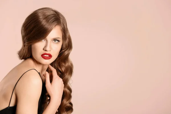 Krásná mladá žena s dlouhé vlnité vlasy na světlé pozadí — Stock fotografie