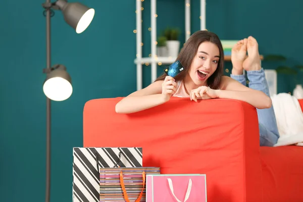 ソファの上のクレジット カードを持つ若い女性 オンライン ショッピング — ストック写真