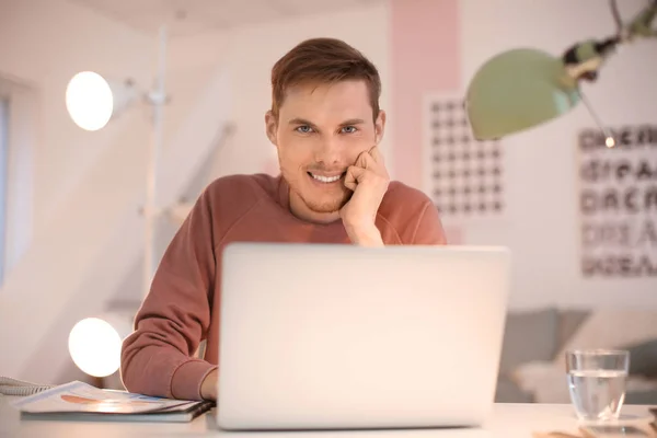 Jovem trabalhando com laptop dentro de casa — Fotografia de Stock