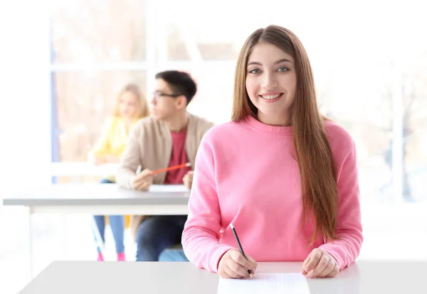 Vrouwelijke student nemen examen in klas — Stockfoto