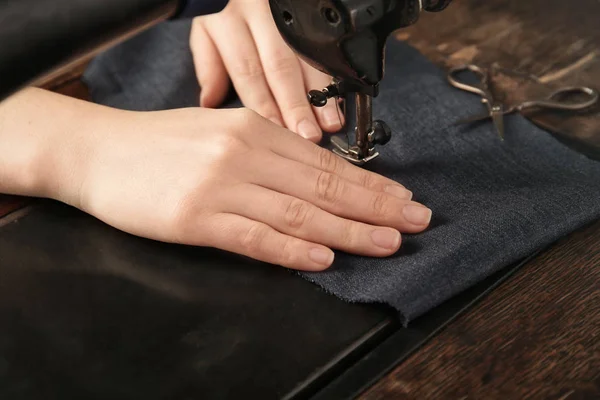 Donna che cuce sulla macchina con filo nero, primo piano — Foto Stock