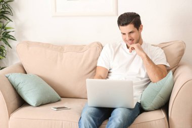 Genç adam ev ofis içinde laptop ile çalışma