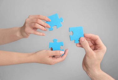 Tutan insanlar birlikte gri arka plan üzerinde adet bulmaca. Birlik kavramı