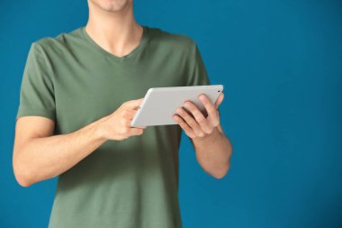Tablet bilgisayar renk arka plan üzerinde kullanan adam