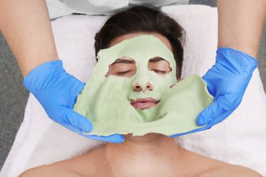 Güzellik salonda yüz maskesi ile genç adam