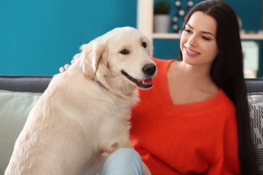 Genç kadın ile köpek kapalı. Evde beslenen hayvan ve sahibi arasındaki dostluk