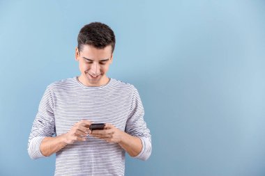 Renk arka plan üzerinde telefon kullanan genç adam