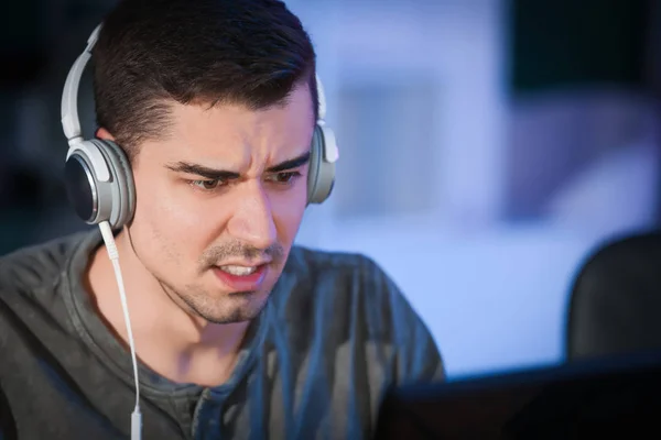 Ung mand med hovedtelefoner spiller videospil ved turneringen - Stock-foto