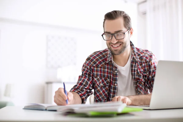 Student med laptop studerar vid bord inomhus — Stockfoto