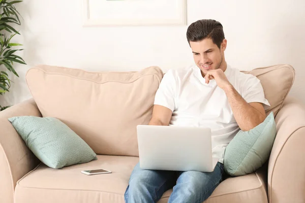 Jeune homme travaillant avec un ordinateur portable dans le bureau à domicile — Photo