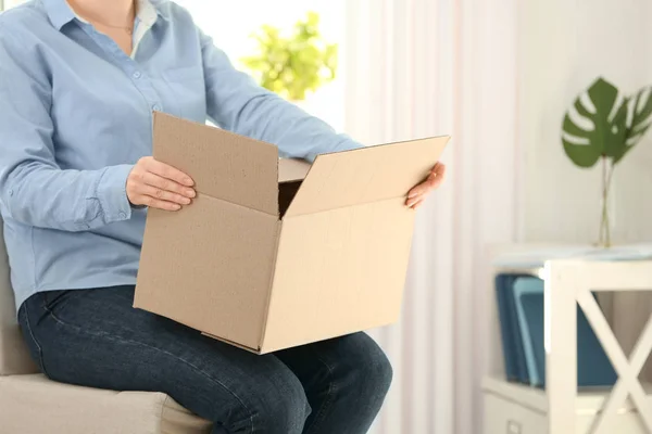 Young woman unpacking parcel indoors — Stock Photo, Image