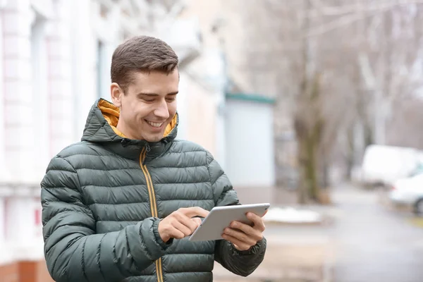 Молодой человек за планшетным компьютером на улице — стоковое фото