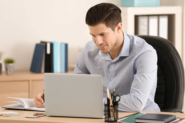 Jeune homme travaillant à table au bureau — Photo