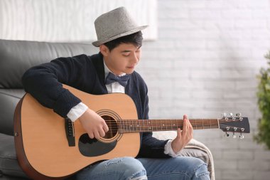 Kapalı gitar ile yakışıklı hipster portresi