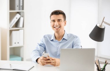 Genç adam masada kapalı telefon kullanma