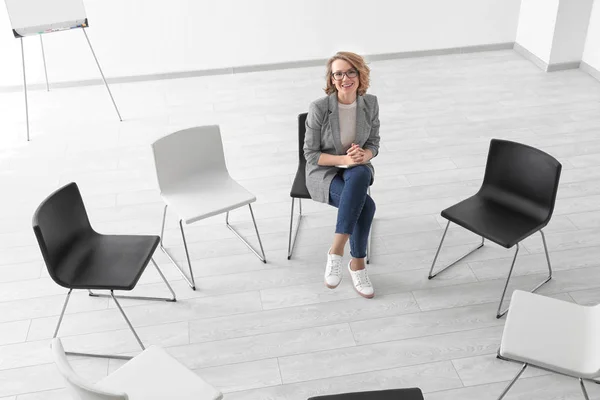 Female psychologist in room with chairs prepared for group psychotherapy session — Stock Photo, Image