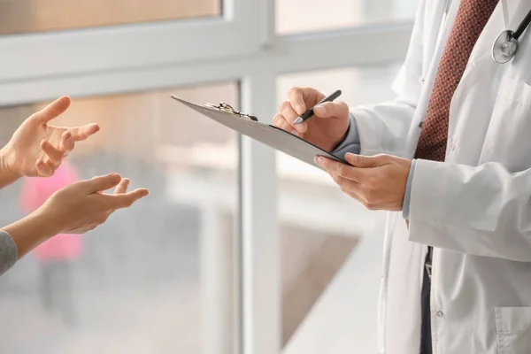 Doctor consulting patient in clinic — Stock Photo, Image