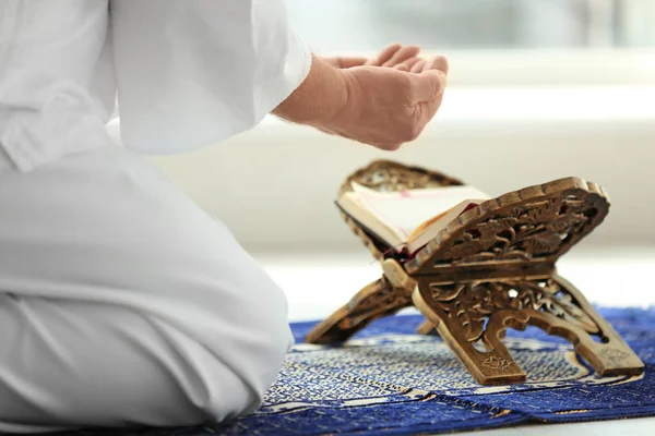 Senior Muslim man praying over Koran, indoors — Stock Photo, Image