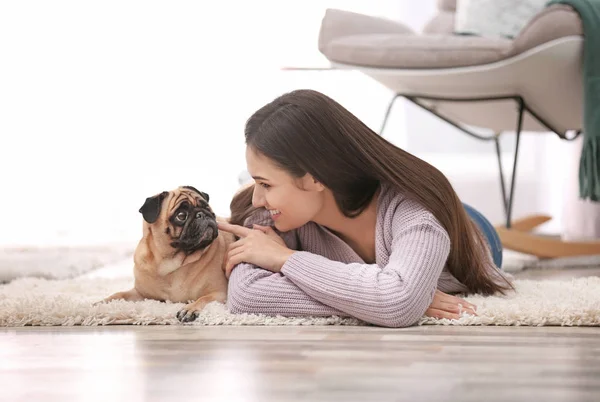 Vrouw met schattige hond thuis. Vriendschap tussen huisdier en eigenaar — Stockfoto