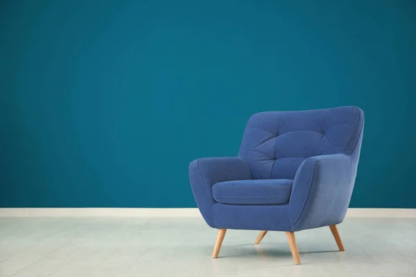 Comfortable armchair against color wall in empty room — Stock Photo, Image