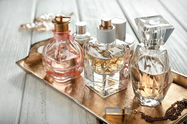 Metal tray with perfume bottles on table