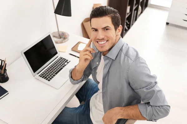 Jeune homme parlant sur un téléphone portable tout en travaillant au bureau — Photo