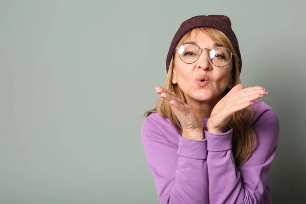 Feliz sênior mulher no hipster roupa no cinza fundo — Fotografia de Stock