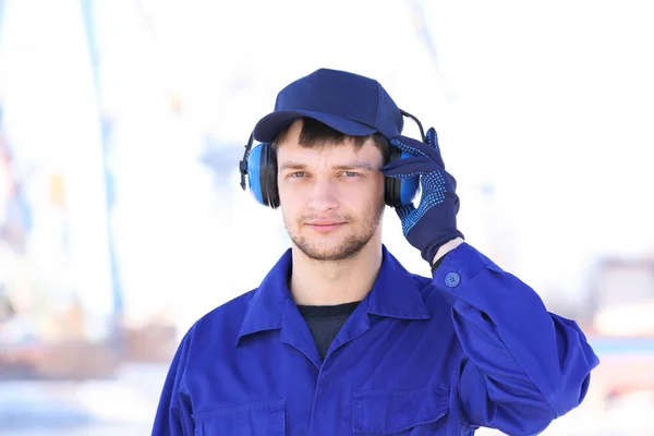 Mannelijke werknemer met een koptelefoon buitenshuis. Hoorzitting beschermende uitrusting — Stockfoto