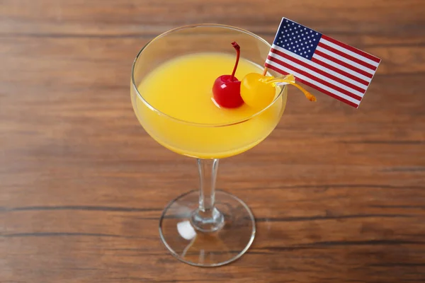 Alcoholic cocktail and small American flag — Stock Photo, Image