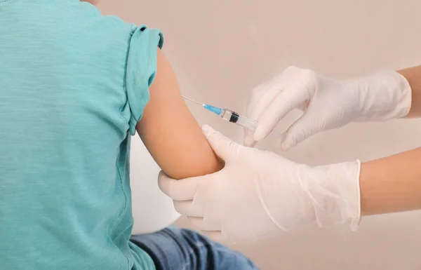 Médico vacunando a un niño pequeño — Foto de Stock