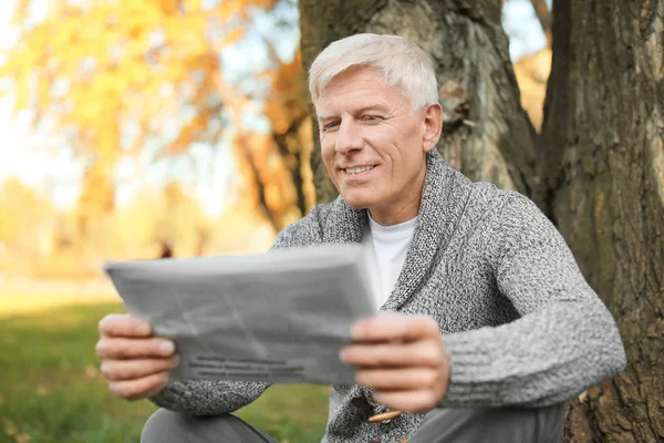 Стильный зрелый мужчина читает газету — стоковое фото