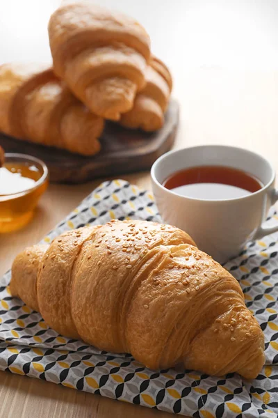 Välsmakande croissant och en kopp te — Stockfoto