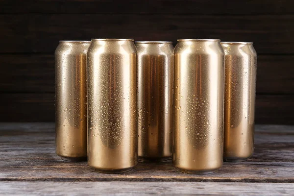 Latas de cerveza sobre mesa de madera — Foto de Stock