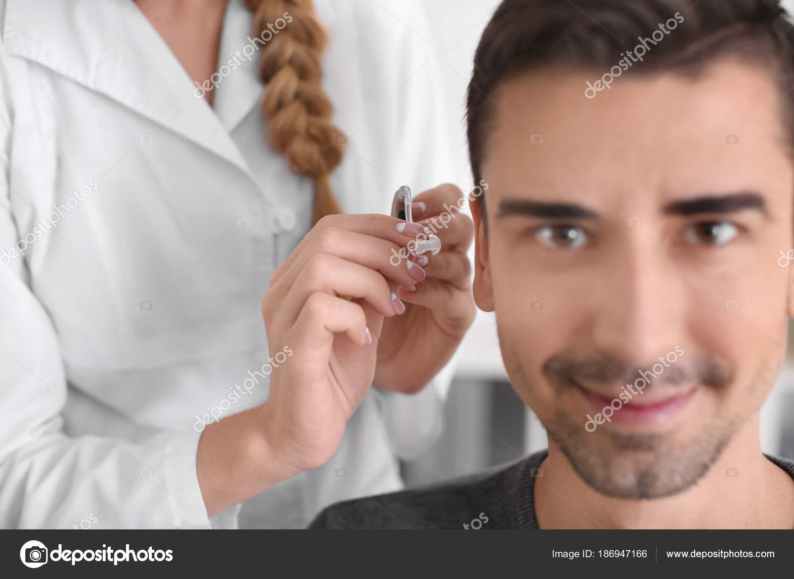 Otolaryngologist Putting Hearing Aid Patient's Ear Hospital Stock Photo