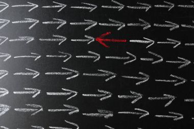 Chalkboard with arrows and one pointing in different direction