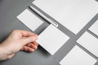 Boş kağıt gri arka plan üzerinde tutan kadın